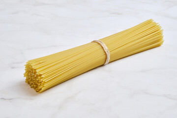 Pasta bundle on light marble surface ready for cooking a delicious meal