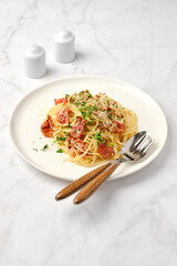 Delicious plate of spaghetti carbonara with bacon and cheese on a marble table