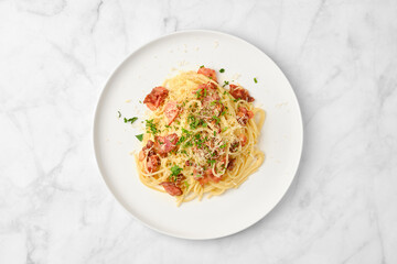 Delicious spaghetti dish with cheese and bacon served on a white plate