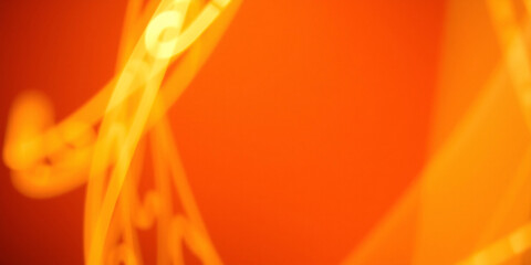 Golden swirling light trails creating an abstract pattern on an orange background