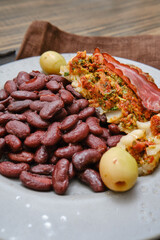 Delicious dish of seasoned beans served with flavorful stuffed meat and olives