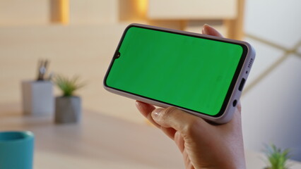 Woman holding horizontal mockup mobile phone at home office closeup. Freelancer 