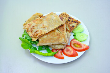 Freshly baked appetizing Turkish tortillas - Gozleme with spinach, cheese  on a white board. Space for text. Handmade Turkish traditional pastries. Ispanakli, otlu peynirli gozleme. Tahinli Katmer