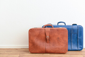 Blue and brown retro leather suitcases on floor in room