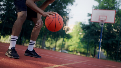 African American sportsman bounces the ball on the court, training before upcoming competitions