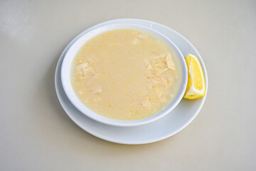 Homemade turkish soup Tavuk Suyu corbasi in a white ceramic soup plate.Turkish noodle chicken broth soup on a plate. Turkish meal (sehriyeli tavuk suyu corbasi). Ezo Gelin Corbasi. Islkembe, corbasi