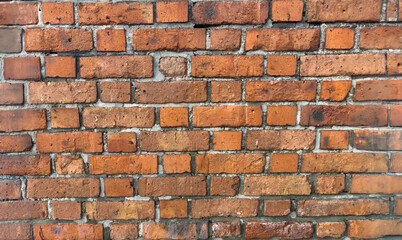 Obraz premium Weathered Red Brick Wall with Textured Surface, Aged Mortar Lines, and Rustic Industrial Appearance