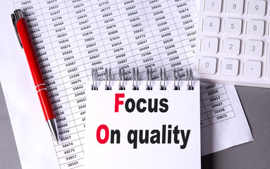Focus on quality text on a spiral notebook with financial documents, a calculator, and a red pen
