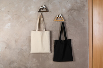 Eco bags hanging on grey wall. Mockup for design