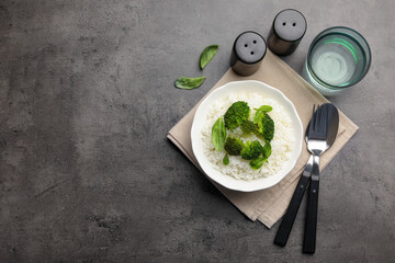 Tasty rice with broccoli served on grey table, top view. Space for text