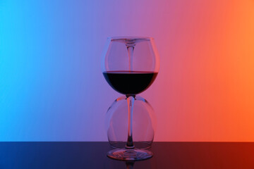 Wine glasses on table against color background
