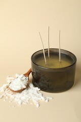 Soy wax, candle and spoon on beige background