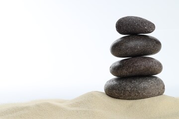 Stack of rocks on sand against white background, space for text. Harmony and life balance