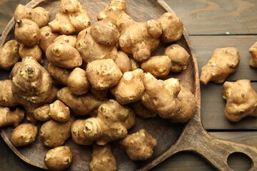 Raw Jerusalem artichokes on wooden table, top view