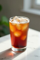 Iced cold brew coffee in glass, white marble table, refreshing, afternoon, summer