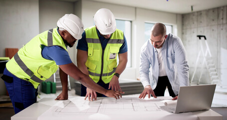 Diverse group of professionals inspecting house interior during construction