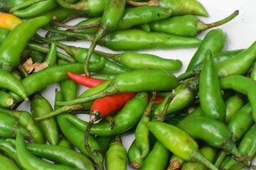 Green chillies laying on white