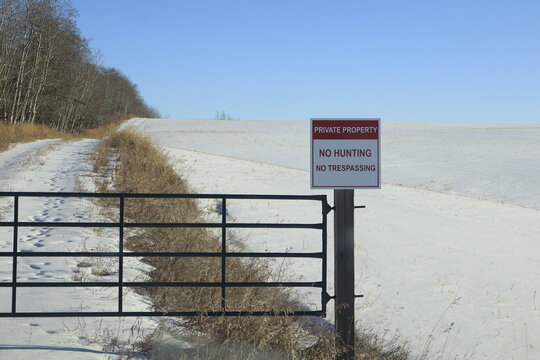 A no hunting sign, posted on a post to a swinging gate. 