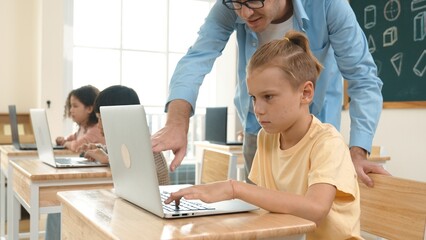 Smart caucasian boy using laptop to generated AI by coding engineering prompt. Diverse student learning or studying programing system while attending in STEM technology class. Technology. Pedagogy.