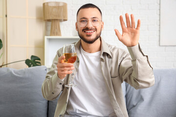 Young man with wine video chatting with girlfriend at home. Online dating