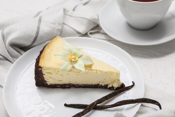 Plate with piece of sweet vanilla cheesecake on white background, closeup