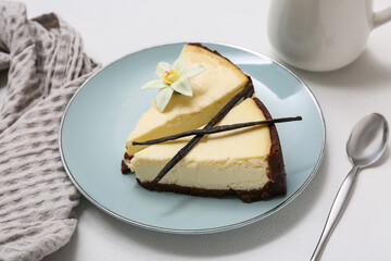 Plate with pieces of sweet vanilla cheesecake on white background