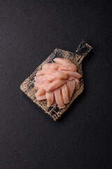 Fototapeta premium Raw chicken or turkey fillet cut into slices with salt, spices and herbs