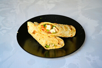 Lavash doner kebab ( soslu kasarli zurna doner durum )  or shawarma sliced in plate isolated.  Tavuk Et Doner Durum. Hatay Iskenderun usulu bazuka tavuk doner durum. 