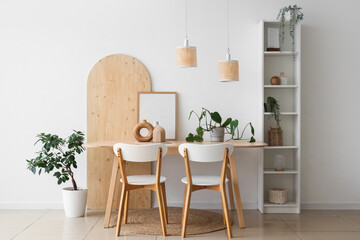 Interior of light room with dining table, shelf unit and plants