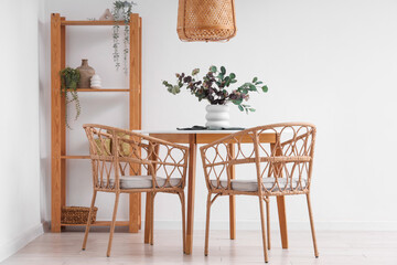 Interior of light room with dining table and shelf unit