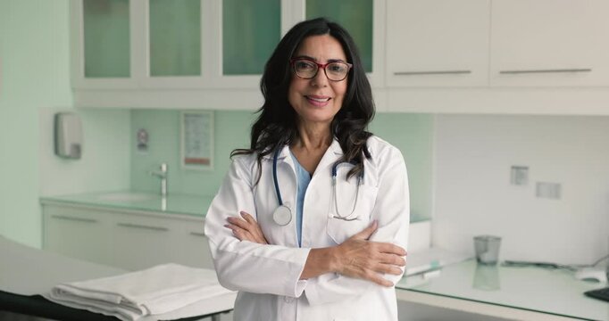 Portrait of competent and reliable middle-aged Caucasian general practitioner wear white medical coat posing with arms-crossed in examination room. Health-care worker, mission, professional occupation