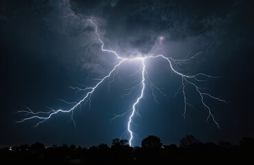 Striking lightning bolt with extensive branching against stormy sky. Electric strike illuminates dark night over trees silhouette. Powerful energy discharge, thunder, rain weather event concept. High