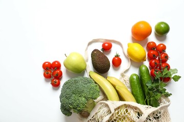 String bag with vegetables and fruits on color background