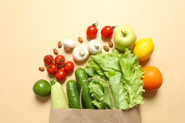 Paper bag, vegetables and fruits on color background