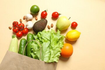 Paper bag, vegetables and fruits on color background