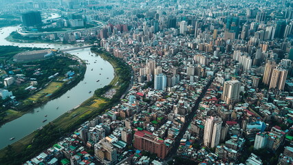 Fototapeta premium Top view of Taipei, Taiwan city, river running through the city, mix of modern skyscrapers, old buildings, and green parks