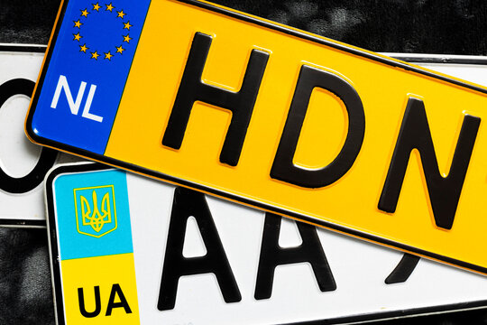 Two types of car license plates, white and yellow. Below is a white Ukrainian license plate with state symbols. Above is a yellow Dutch license plate with the European Union symbol.
