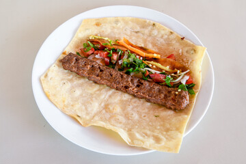 Grilled Turkish Adana, Urfa  Kebab with grilled vegetables, onion and rice on plate. Urfa, Adana durum.
