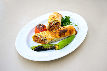 Grilled Turkish Adana, Urfa  Kebab with grilled vegetables, onion and rice on plate. Urfa, Adana durum.

