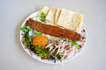 Grilled Turkish Adana, Urfa  Kebab with grilled vegetables, onion and rice on plate. Urfa, Adana durum.
