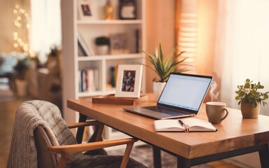 Fototapeta premium Cozy Home Office Setup with Laptop, Notebook, Mug, and Plants