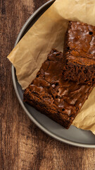 Close-up of freshly baked brownies on parchment paper, showcasing a rich chocolate texture, perfect for dessert or baking concepts.