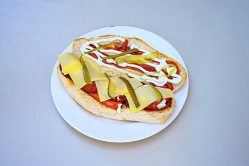 Close-up shot of Izmir's famous Turkish Traditional Kumru Sandwich, Ceşme Kumru, patso ingredients ready to eat salami, soudjouk, tomato, cheddar cheese and fried cheese. Yengen sandvic. Izmir karisik