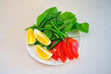 Green salad with arugula, lamb and tomatoes. Healthy vegan dish. Top view at table. Turkish Coban (choban) salata or Shepherds salad, Akdeniz salad in white bowl.