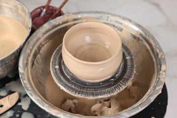 Hobby and craft. Beautiful bowl on potter's wheel in workshop, closeup
