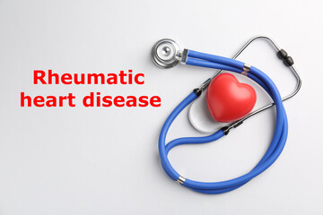 Rheumatism. Stethoscope, red heart and words Rheumatic Heart Disease on white background, top view