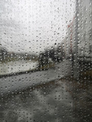 Raindrops on Glass Bus Stop with Urban Street View