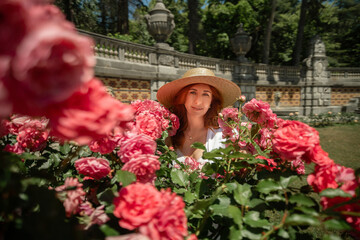 A woman is standing in a field of pink roses