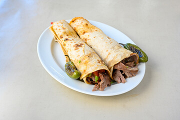 Lavash doner kebab ( soslu kasarli zurna doner durum )  or shawarma sliced in plate isolated.  Tavuk Et Doner Durum. Hatay Iskenderun usulu bazuka tavuk doner durum. 
