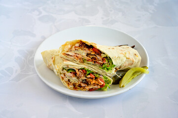 Lavash doner kebab ( soslu kasarli zurna doner durum )  or shawarma sliced in plate isolated.  Tavuk Et Doner Durum. Hatay Iskenderun usulu bazuka tavuk doner durum. 